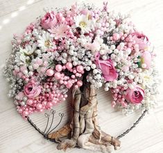 a tree with pink and white flowers in the center is surrounded by chains on a wooden floor