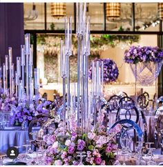 a table set up with purple flowers and silverware for an elegant wedding or reception