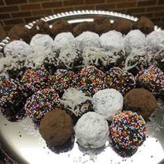 a platter full of chocolate and sprinkle covered donuts