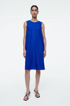 This simple mini dress rings true to the considered design ethos at COS. Offered in a perennial black hue, it's styled in a clean A-line silhouette and has an enthraling twist detail that frames the V-back. It is crafted from a TENCEL™ Lyocell and linen blend that's light in balmy weather. Relaxed fitSide seam pocketsTENCEL™ is a trademark of Lenzing AG. TENCEL™ Lyocell is made from renewable wood sources, using a process that recycles 99% of all chemicals and water  Shell: 77% TENCEL™ Lyocell, 23% Linen. Excluding trims / Machine wash Back length of size 6 is 95.3cm / Model wears a size 6 Simple Mini Dress, Bright Blue Dresses, Cos Tops, Dress Rings, Knitwear Cardigan, New Arrival Dress, Shop Swimwear, V Shape, Occasion Wear