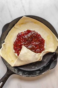 an uncooked pizza in a cast iron skillet