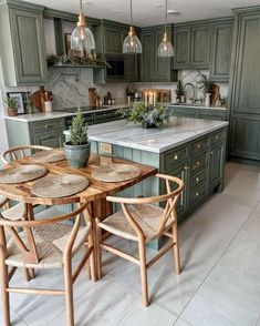 a kitchen with green cabinets and wooden chairs