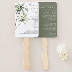 the palm tree fan is next to a white flower and two wooden spatulas