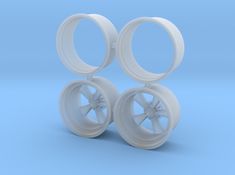 two white plastic wheels with spokes on a blue background