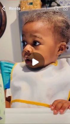 a toddler is looking at the camera while wearing a bib