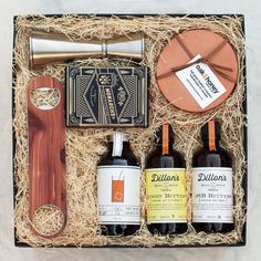 an open gift box containing three bottles of wine and a bottle opener