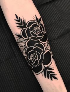 a black and white rose tattoo on the arm