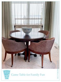 a dining room table with four chairs and a bowl on top of it in front of a window