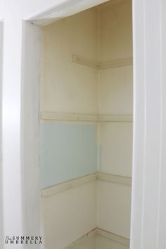 an empty closet with white walls and blue paint on the wall is seen in this image