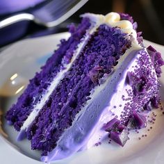 a slice of purple cake with white frosting on a plate