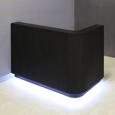 a black reception table with white lights on the top and bottom, in front of a gray wall