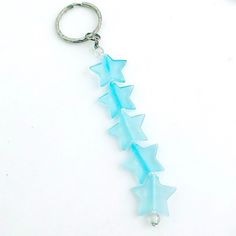 a blue glass arrow shaped keychain on a white surface