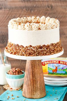 a cake on a wooden stand with nuts around it