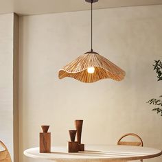 a white table and chairs with a light hanging from the ceiling over it in a dining room