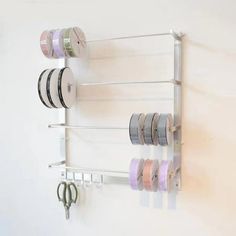 a white wall mounted shelf filled with different types of ribbons