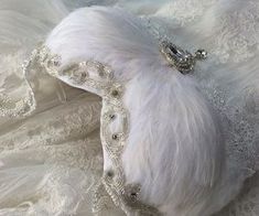 a close up of a white dress with feathers on it