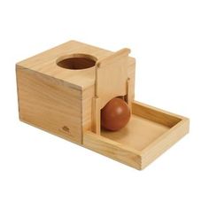 a wooden box with an egg in it and a brown ball on the inside of it