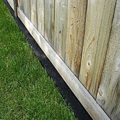 a wooden fence with grass growing next to it