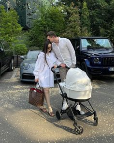 a man and woman standing next to a baby carriage