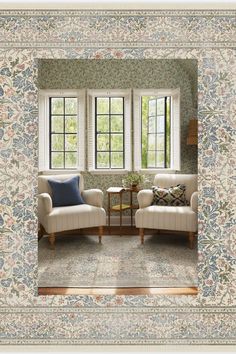 a living room with two chairs and a table in front of three windows that have floral wallpaper on them