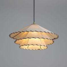 a light hanging from a ceiling with a white lamp shade on it's side