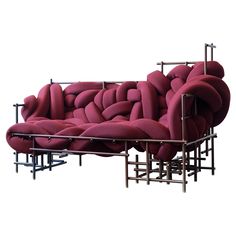 a couch made out of multiple pieces of metal and pink fabric, sitting in front of a white background