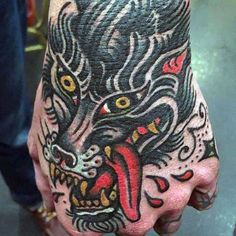 a man's hand with a tattoo on it and an animal head in the middle