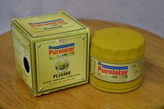 a yellow container sitting on top of a wooden table next to a cardboard box that says purolator