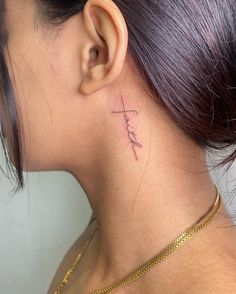 a woman's neck with a small tattoo on the back of her left ear