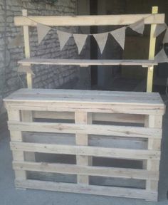 an outdoor bench made out of pallet wood with bunting and flags on it