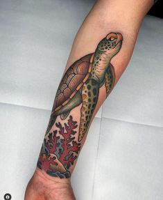 a person with a tattoo on their arm has a turtle and corals on it