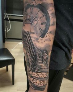 a man's arm with a clock and stairs tattoo on the left side of his leg