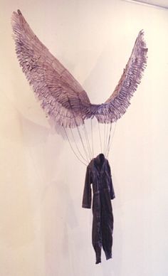 an art piece hanging on the wall with wings attached to it's back end