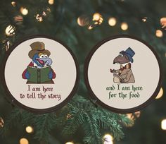 two cross - stitch christmas ornaments hanging from a tree with lights in the background and an ornament that says i am love to tell the story