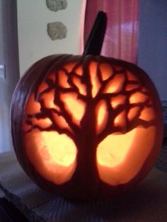 a carved pumpkin with a tree on it