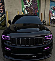 the front end of a black jeep with purple lights on it's grilles