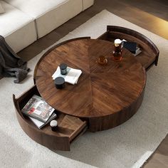 a living room with a couch, coffee table and magazines on the floor in front of it