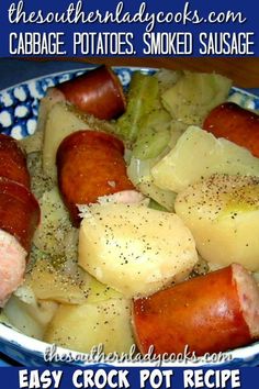 a blue and white bowl filled with cooked potatoes, sausages and other food items