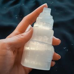 a hand holding a small plastic bottle with ice cubes on it's side