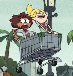 two people are pushing a shopping cart through the street with palm trees in the background