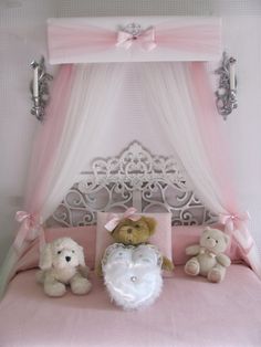 three teddy bears sitting on top of a pink bed