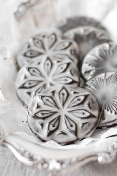 three decorative cookies sitting on top of a silver plate