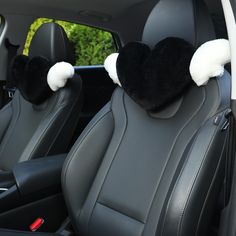 the interior of a car with two black and white plush headrests on it