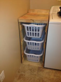 three laundry baskets are stacked in front of the washer and dryer