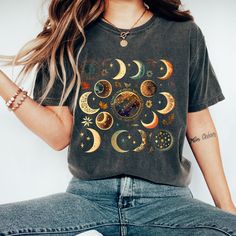 Watercolor Moon Phase Tee in Comfort Colors with 15 Unique and Playful Phases: Introducing our beautiful and whimsical Moon Phase T-shirt, perfect for anyone who loves celestial designs and wants to add a touch of magic to their wardrobe. Featuring 15 different fun and playful moon phases scattered across a stunning watercolor print, this t-shirt is truly one-of-a-kind. The eye-catching watercolor print features 15 unique and playful moon phases, each one more whimsical and fun than the last. The soft, muted colors of the print blend beautifully with the vintage-inspired Comfort Colors material, giving the shirt a classic, rustic feel. Whether you're a lover of all things celestial or just looking for a fun and playful shirt to add to your collection, our Moon Phase T-shirt is the perfect Celestial Moon Print Crew Neck T-shirt, Bohemian Short Sleeve T-shirt With Sun And Moon Design, Celestial Short Sleeve Tops With Moon Print, Bohemian Short Sleeve T-shirt With Moon Print, Casual Moon Print Tops For Festival, Festival T-shirt With Moon Print And Short Sleeves, Bohemian Short Sleeve Tops With Moon Print, Festival Graphic Tee With Moon Print, Graphic Tee With Moon Print For Festival