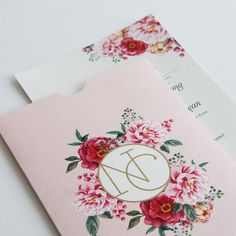 two envelopes with floral designs on them and the letter d in gold, white, and pink