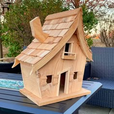 a wooden bird house sitting on top of a table