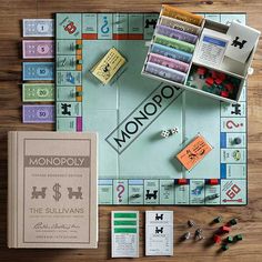 the monopoly board game is laid out on a wooden table