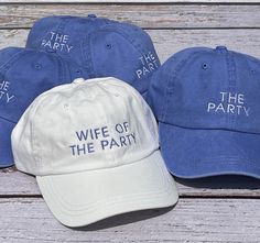 three hats with the words wife of the party on them sitting on a wooden bench