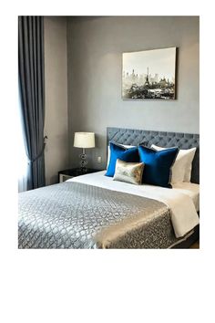 a bed with blue and silver pillows in a bedroom